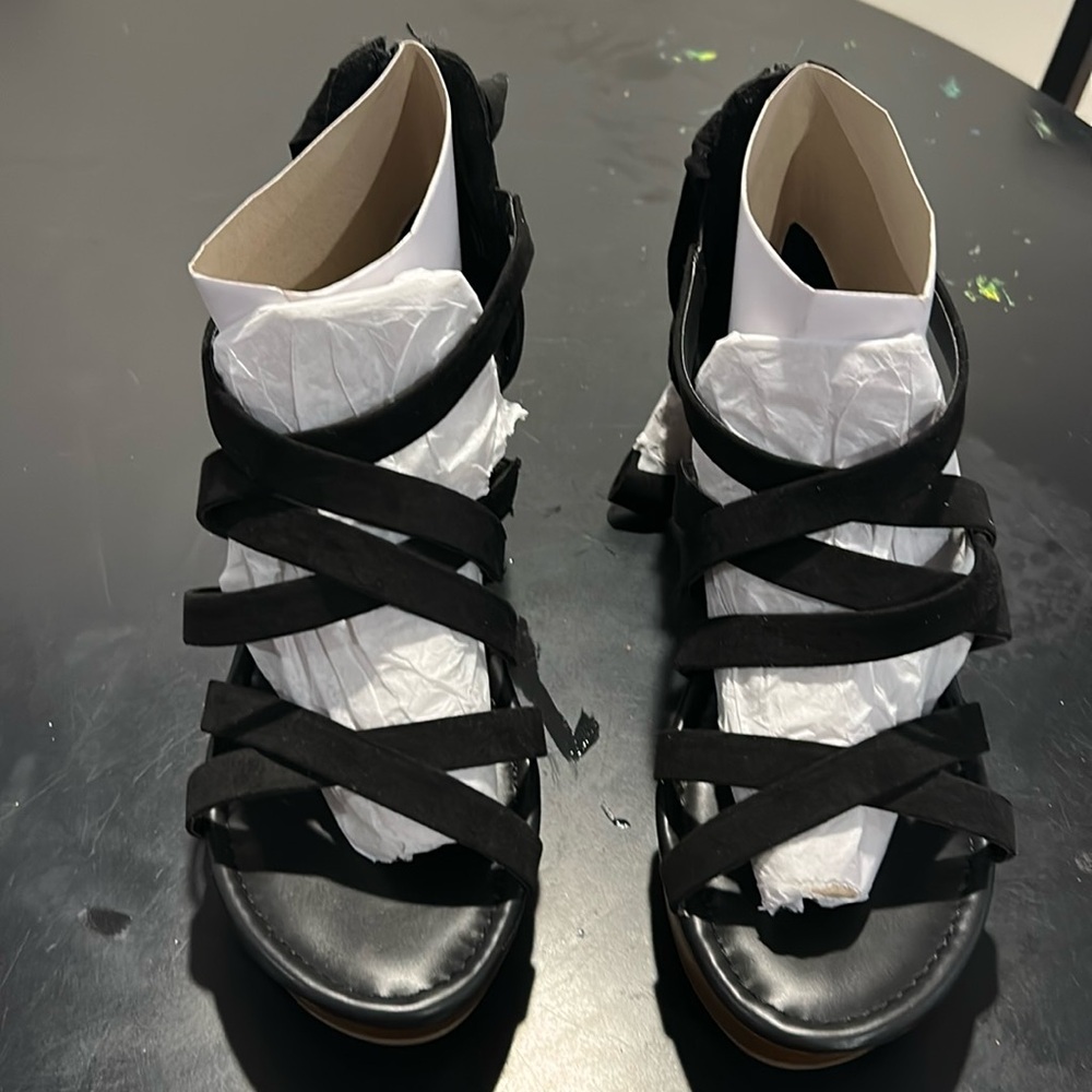 Black torrid sandals that lace around the legs.